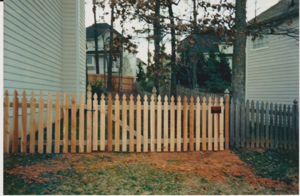 This 4 ft space picket cedar French Gothic fence is constructed using 2x4 runners and 4x4 French Gothic post and one by four French Gothic cedar pickets Forest Pine Drive Ball Ground, GA 30107
